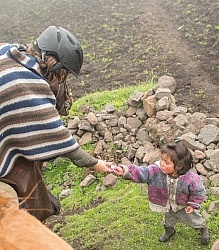 Ali gives a my little pony to a small Ecuadorian girl in the hig